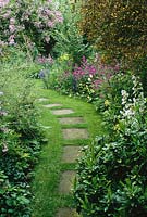 Stepping stones in grass path with mixed border