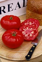 Tomato 'Jack Hawkins' - tomotoes on wooden chopping board with knife