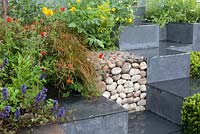 Ooooh ...it makes me wonder. Malvern Spring Gardening Show 2014, inspired by the classic Led Zeppelin song 'Stairway to Heaven', and the Giant's Causeway rock formation, with cubes of geum, and buxus and gabions - Designer: Teresa Rham - Sponsor: The Dingle Nurseries and Gardens