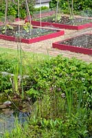 Small garden showing wildlife pond and raised beds.