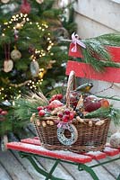 Decorative baskets stuffed with apples and Malus, Punus spinosa - blackthorn, corn ears, peanuts and  ring as birdseed - branches of Pinus - pine