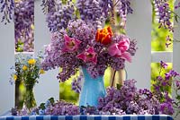 Outdoor spring display. Flowering Wisteria. Jug of tulips and syringa. Forget me nots and buttercups in a vase.