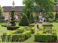 Box parterres, filled with lavender or roses, amongst huge yew topiary pieces created over 20 years.