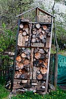 Nesting opportunities for wild bees, an insect hotel made from logs with holes drilled into them