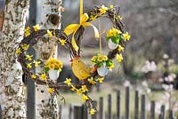 Heart made from stems of Betula decorated with Primula and duck eggs, chicken and garland of Narcissus - daffodils, with yellow ribbon 
