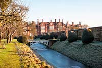 Inner moat, bridge, house and apple trees at Helmingham Hall, Suffolk