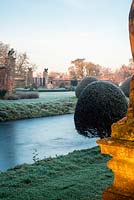Moat and topiary with frost at Helmingham Hall, Suffolk