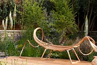 Royal Bank of Canada Garden. Garden seat created out of steamed bent wood by Tom Raffield with Eremurus himalaicus and Erigeron karvinskianiks growing nearby. 