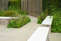 Drystone wall seats and stone terrace with clipped dome of Taxus baccata, grasses and perennials including Deschampsia flexuosa, Baptisia 'Dutch Chocolate', Astrantia 'Hadspen Blood'- RHS Chelsea Flower Show 2015