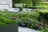 The Telegraph Garden inspired by the De Stijl Movement. This geometric garden includes: Tulipa 'Red Hat' and 'Spring Green', Aquilegia vulgaris, Digitalis alba, Iris sibirica 'Shirley Pope' with Carpinus betulus and Taxus baccata cubed hedges.