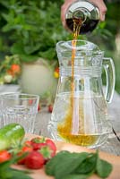 Adding Pimm's to a jug of lemonade, ingredients in foreground