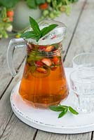 Jug of Pimm's and lemonade with Mint, Cucumber and Strawberries added to the jug