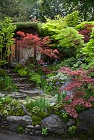 View from border to stone path leading to hut. Edo no Niwa - Edo Garden by Ishihara Kazuyuki Design Laboratory. RHS Chelsea Flower Show 2015