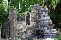 The Evaders Garden, which reflects the bond between helper and evader, and featuring a sculpture of a young pilot seconds after parachuting into France, hiding in the ruins of a war-damaged church. RHS Chelsea Flower Show, 2015