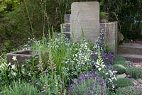 Stone water trough, mixed planting and grave stones - The Evaders Garden, RHS Chelsea Flower Show, 2015