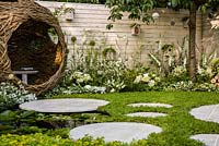 Living Landscapes 'City Twitchers' - view showing circular paved areas, camomile lawn, pond, spherical willow bird hide, nesting boxes, prunus tree and mixed white planting - RHS Hampton Court Flower Show 2015