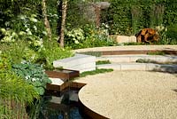 Successive levels in circular form with white stone-chip gravel, rusted-steel water spout and rill with border of white flowering hostas and hydrangeas with copper stems of birch ermanii. Vestra Wealth: Encore - A Music Lover's Garden Silver-Gilt RHS Hampton Court Palace Flower Show 2015medal 