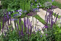 Purple feminine planting with stepping stones marking the decaces since the Charity's inception in The Wellbeing of Women Garden at RHS Hampton Court Palace Flower Show 2015