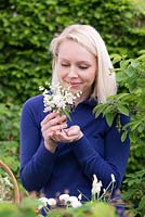 All white posie step by step in May: Mexican orange blossom, Bellis daisy, cow parsley, white grape hyacinths, hawthorn  and lily-of-the-valley. Choisya 'Aztec Pearl', Bellis perennis, Anthriscus sylvestris, Muscari aucheri 'White Magic' , Crataegus laevigata and Convallaria majalis. Arranged in silver jug.