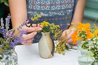 Herbs and edibles posie step by step in August. Cutting stems of fennel to length to create a frothy collar around the top of the vase.