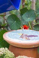 Filling the mosaic bird bath with water