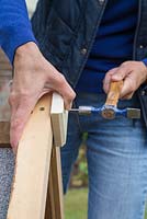 Woman adding a diamond shaped piece of wood to the front