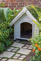 A Dog Kennel with a green living roof made with sedum matting, complete with a York stone path featuring Soleirolia soleirolii syn. Helxine soleirolii