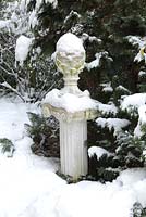 Winter scene with pinecone on pillar against picea - Welsch Garden, Berlin, Germany