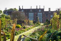 Double borders and house in spring with tulips - Helmingham Hall