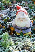 A garden gnome coated with frost.