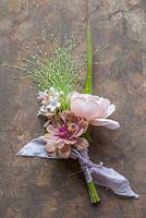 Wedding Buttonhole made with Zinnia elegans 'Queen Red Lime', Rosa 'Ambridge Rose', Panicum elegans 'Frosted Explosion' and Abelia x grandiflora