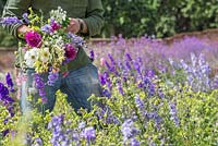 Patrick Cadman holding a bunch of cut flowers. Dahlia, Larkspur, Cosmos, Nicotiana