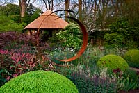 Marcus Harpur Centenary M and G Investments Centenary Windows Through Time. Chelsea Flower Show.  Gold medal winner.  Steel circle sculpture with thatched garden building. Design: Roger Platts Sponsor: M and G 