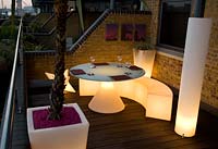 Contemporary balcony overlooking the Thames at Wapping with white plastic illuminated dining furniture