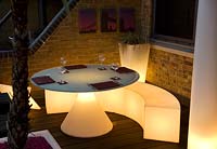 Contemporary balcony overlooking the Thames at Wapping with illuminated plastic dining furniture