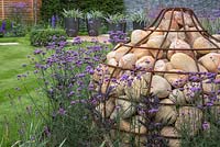 Unique Gabion sculpture shaped like a bulb, with planting of Verbena bonariensis and Actaea