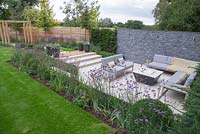 Overview of the sunken seating area surrounded by a border of Verbena bonariensis, Calamagrostis x acutiflora 'Karl Foerster' and Buxus sempervirens balls used to give a sense of privacy