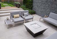 Sunken seating area with a Liquid propane fire pit and dry stone slate wall