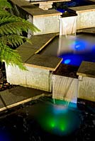 Lights reflecting in water feature at night