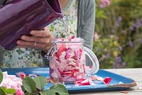 Add water to the glass jar of rose petals