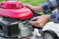 Disconnect the spark plug from the engine to prevent serious injury from the mower blade