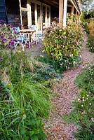 Pathway to the house through autumn perennial and grass borders: Verbena bonariensis, Deschampsia cespitosa, Impatiens glandulifera. Madelien van Hasselt, Vlackeland