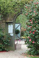 Entrance to the walled garden with Camellias at The Place For Plants, Suffolk, April