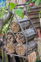 An upcycled wicker wine rack used for Insect houses