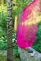 Atlante - Sculpture by Stephane Bernard next to colourful curtains 