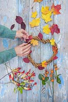 Weaving autumnal leaves into the woven heart wreath
