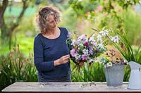 Gabi Reid creating a flower arrangement from her cutting garden with late flowering flowers. September.