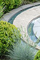 Circular water feature with clipped Buxus sempervirens and Festuca glauca in foreground - 'Collision', RHS Malvern Spring Gardening Show 2011
