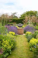 Double herbaceous borders leading to seating