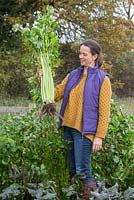 Woman holding overgrown celery
